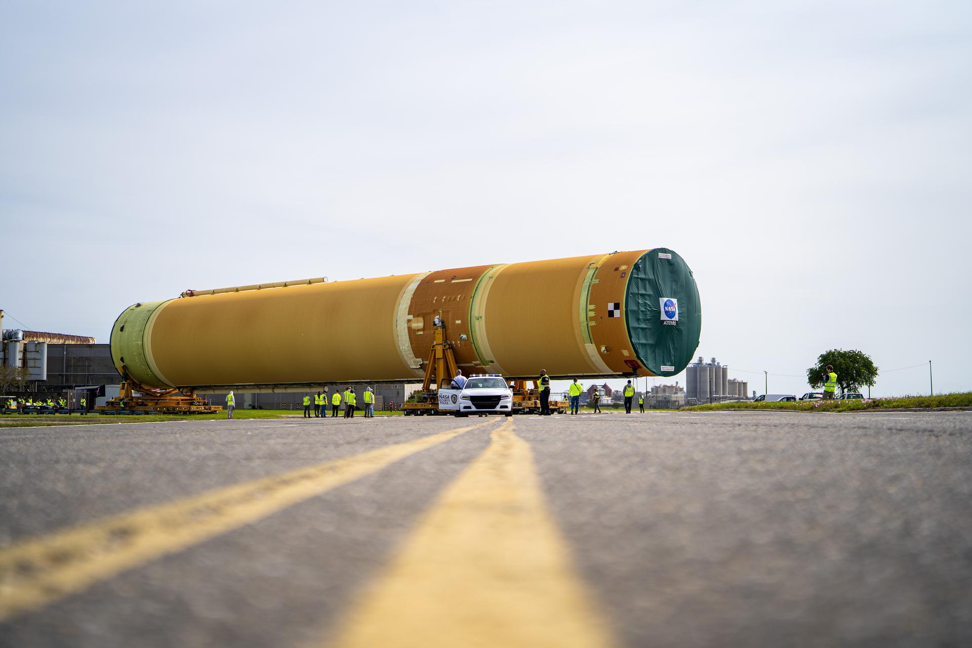 NASA moved the core stage, or the largest section, of the SLS (Space Launch System) rocket that will launch the crewed Artemis III mission in 2027 from the agency’s Michoud Assembly Facility to the agency’s Pegasus barge in New Orleans on April 20. The barge will ferry the top four-fifths – the section containing the liquid hydrogen tank, liquid oxygen tank, intertank, and forward skirt – of the SLS core stage to NASA’s Kennedy Space Center in Florida to complete outfitting and vertical integration.  Teams with NASA and Boeing, the SLS core stage lead contractor, used specialized transporters to guide the top four-fifths from the NASA rocket factory to Pegasus. Prior to the move, technicians added an engine section transportation simulator to the rocket stage for shipment to the Space Coast.  Next year’s Artemis III mission will launch astronauts to Earth’s orbit aboard the Orion spacecraft on top of SLS to test rendezvous and docking capabilities between Orion and commercial spacecraft needed to land Artemis IV astronauts on the Moon in 2028. NASA’s SLS is the only rocket capable of sending Orion, astronauts, and supplies to the Moon in a single launch.